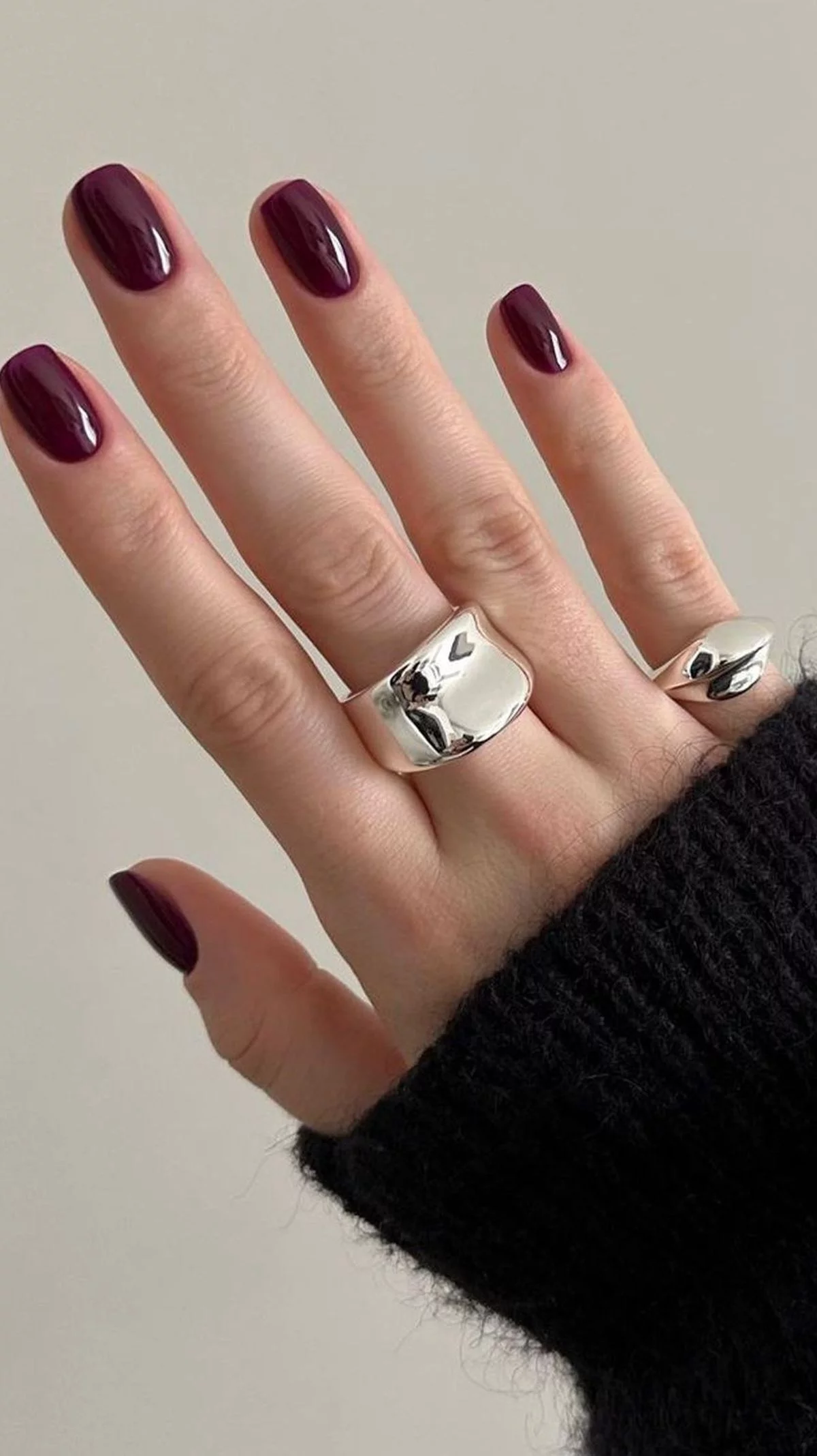 stilvoll gepflegete Nägel in Dunkellila lackiert