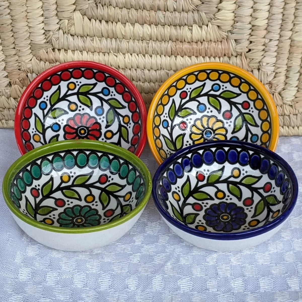 vier Keramikschüsseln in kräftigen Farben bemalt mit Blumenmotiven 
