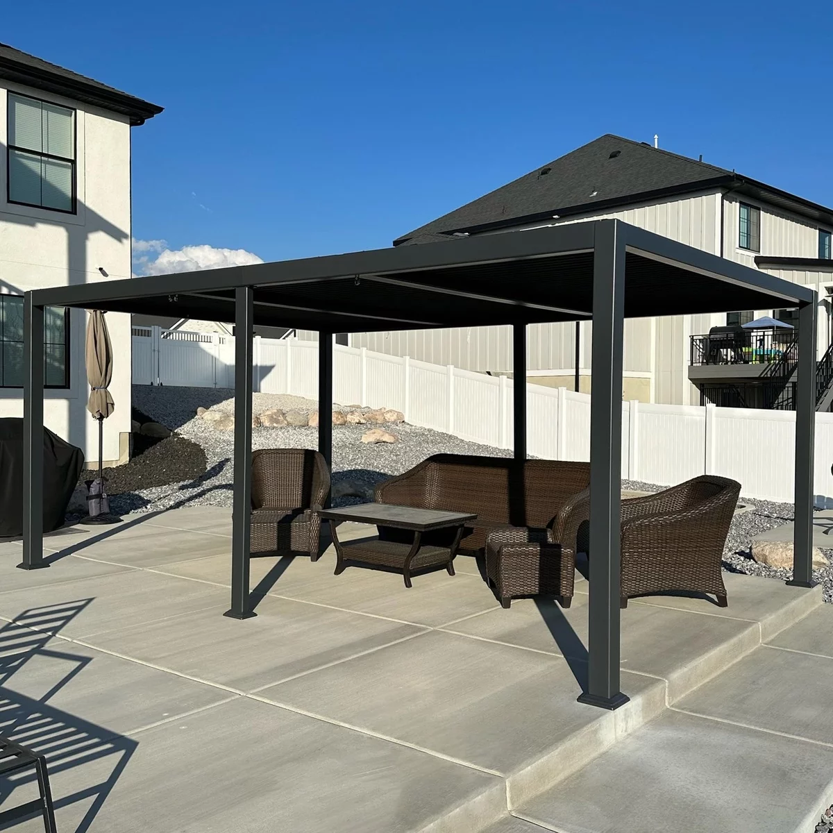 Gartenlaube Terrasse aus schwarzem Metall mit dunklen Outdoor-Möbeln unter Dach 