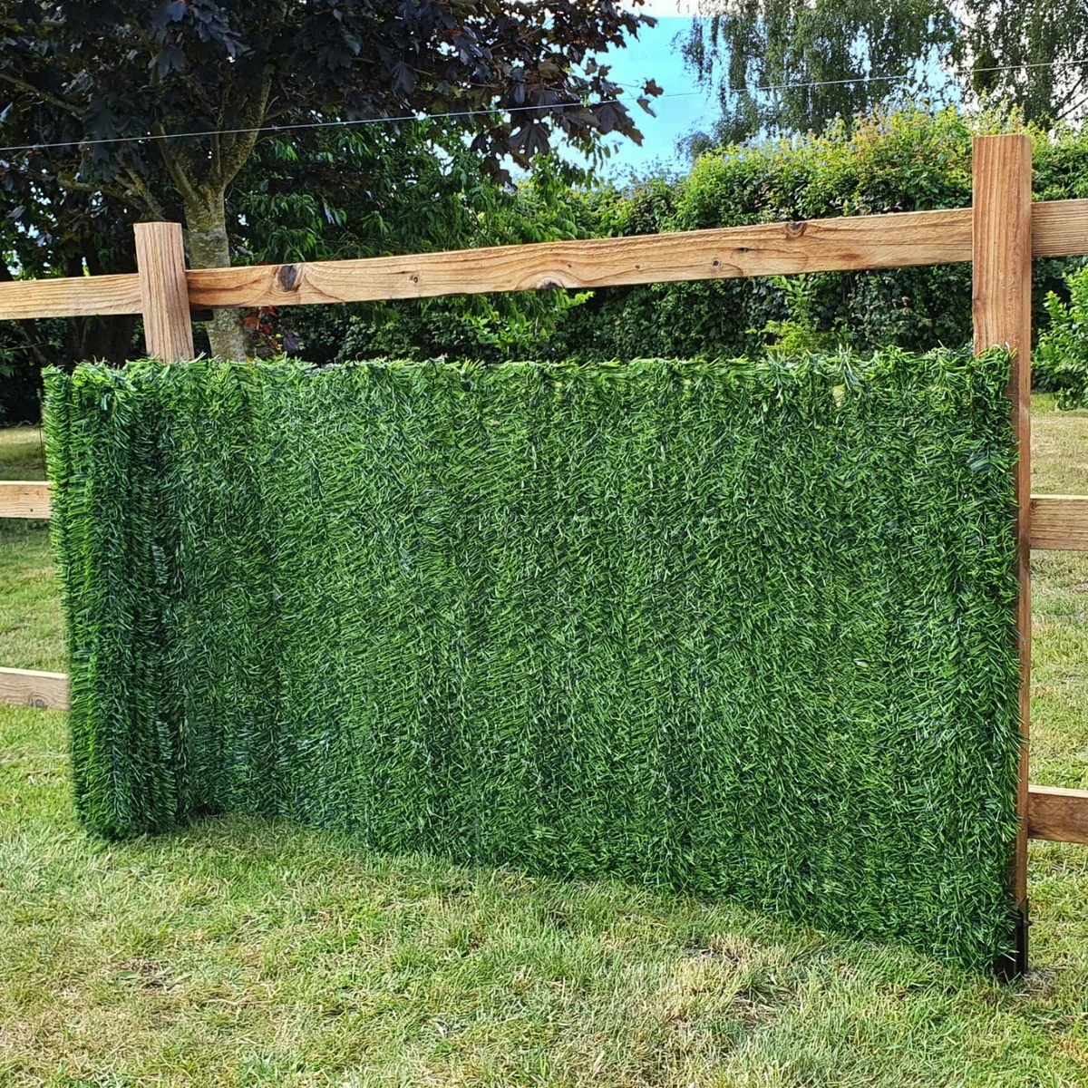 künstliches Gras am Holzzaun sperrt fremde Blicke