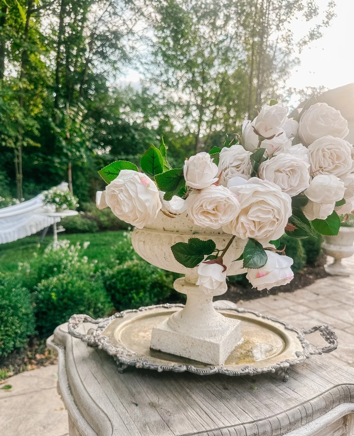 weiße Rosen in Vase aus Marmor auf einem Vintage Tisch 