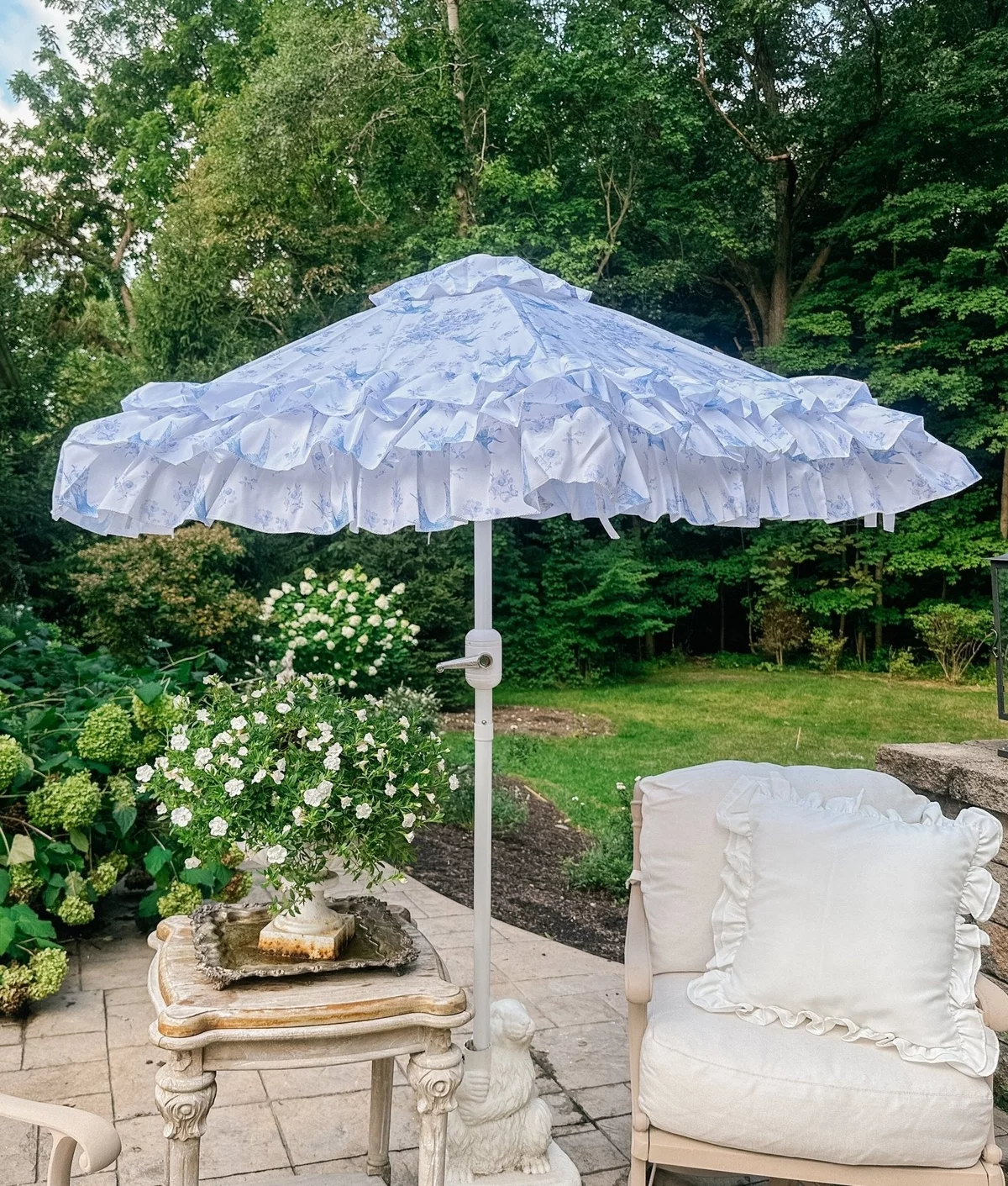 kleiner Tisch mit Blumen, Sonnenschirm und Outddor-Sessel - Shabby Chic Garten 