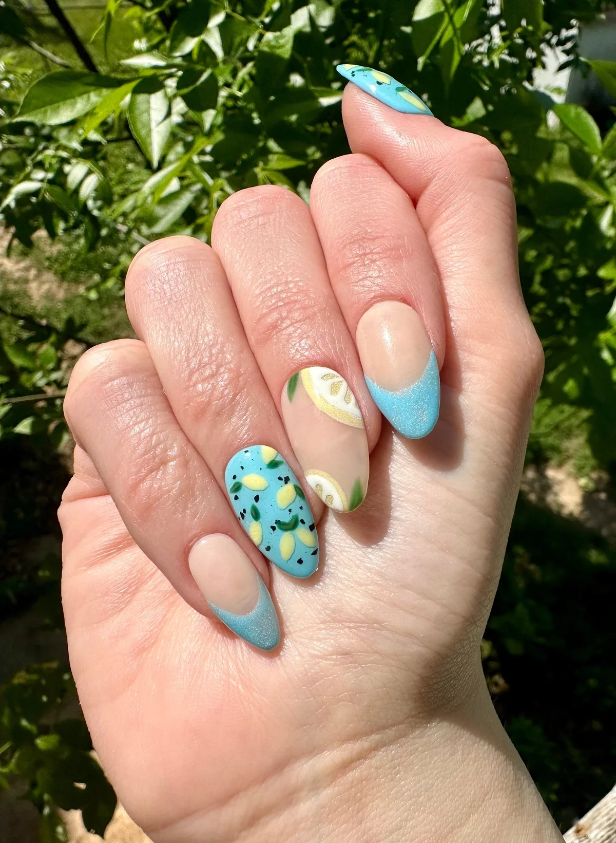 schöne Maniküre in Blau und Beige mit dekorativen Elementen