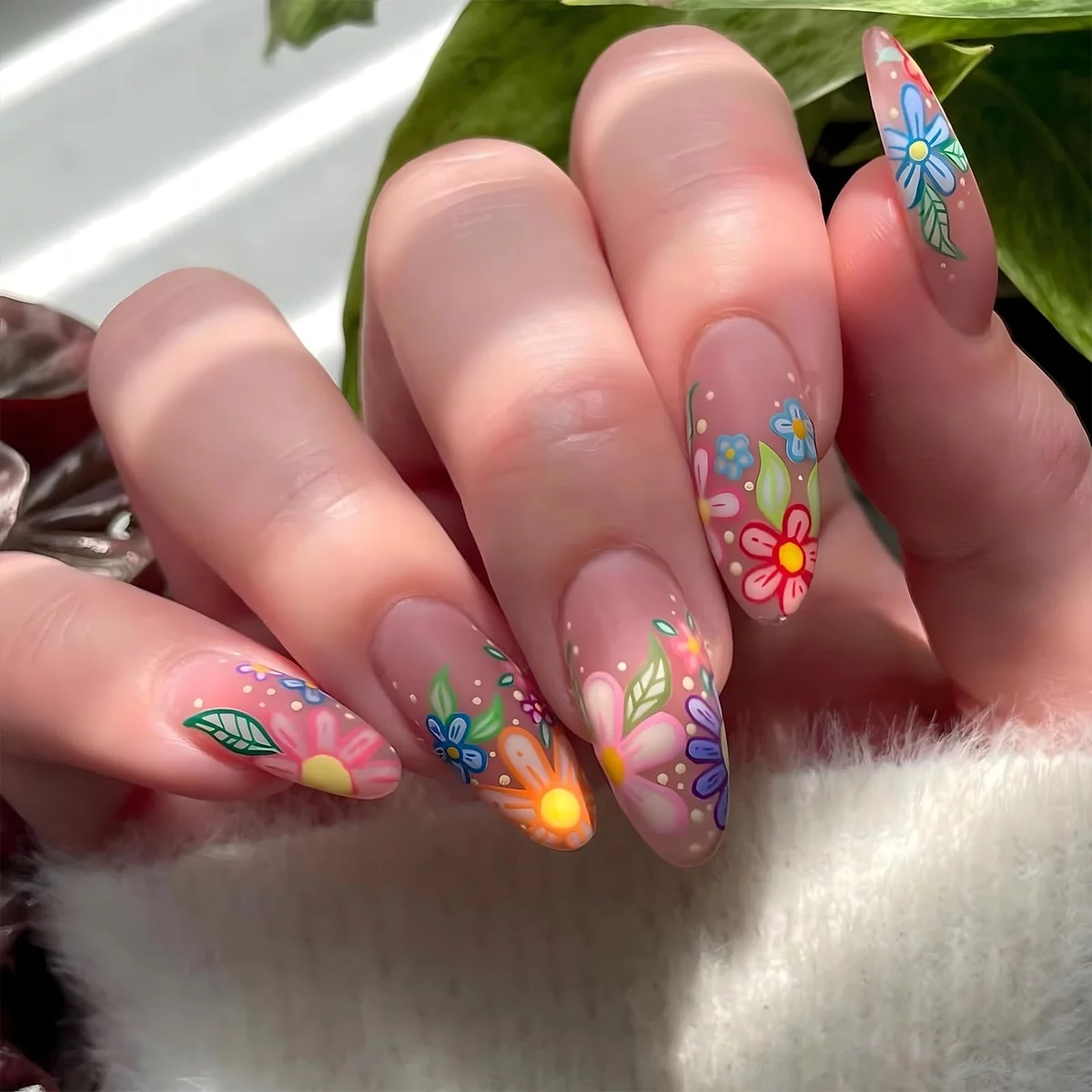 schön gepflegete Frühlingsnägel 2025 dekoriert mit Blüten und Blättern 