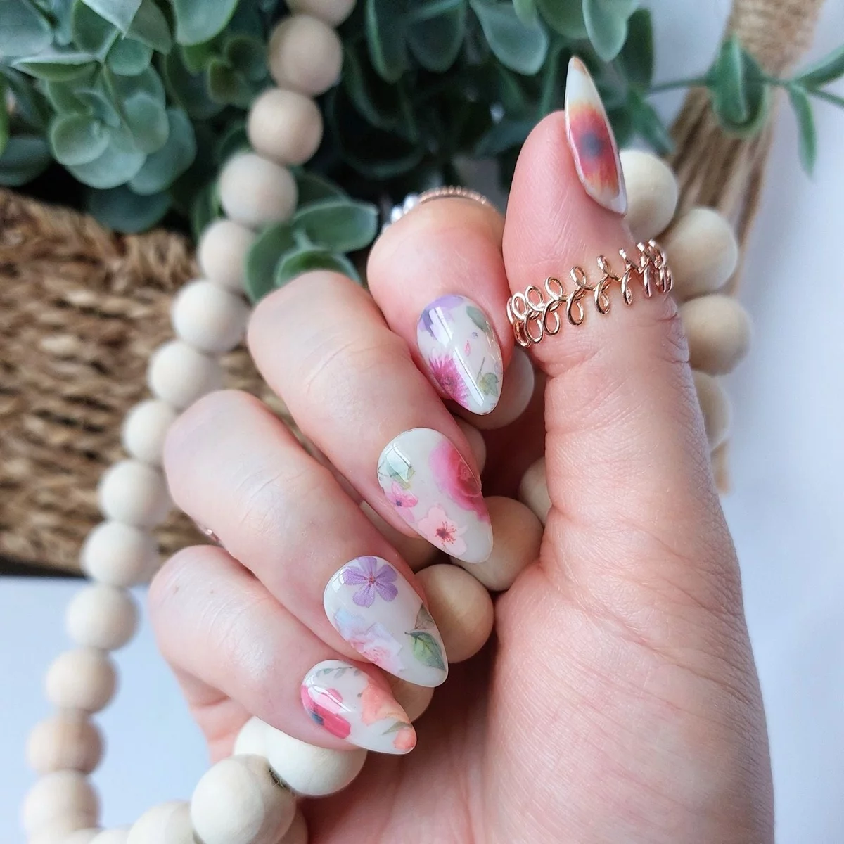 weiß lackoerte Nägel mit Frühlingsblüten in zarten Nuancen geschmückt 