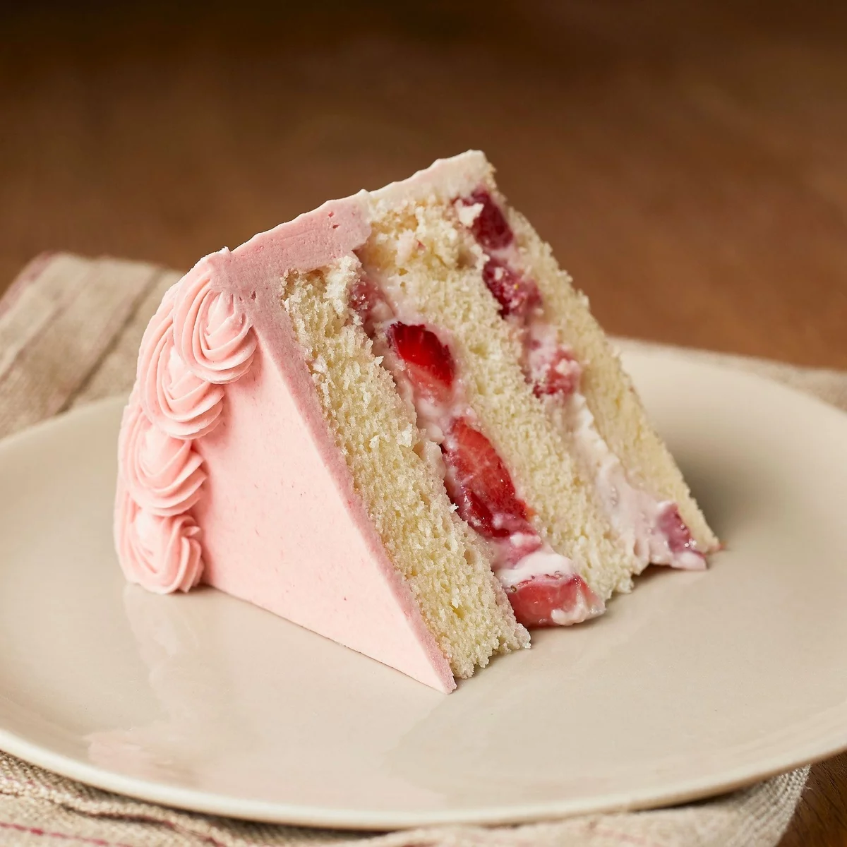 ein Stück rosa Erdbeerkuchen auf dem teller serviert
