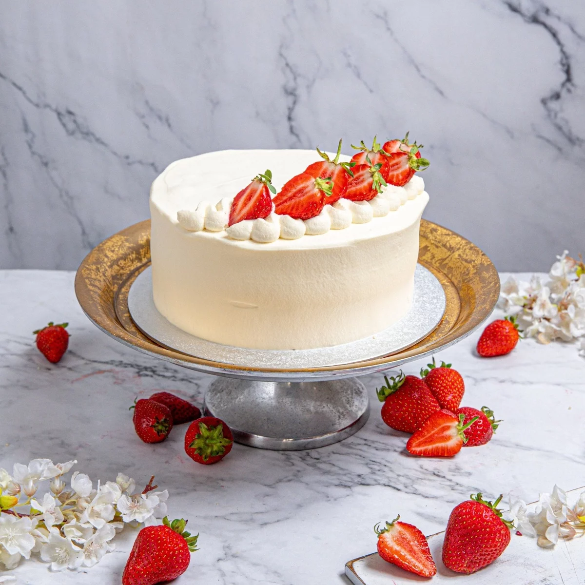  Erdbeerkuchen mit weißer Sahne und frischen früchten geschmückt 