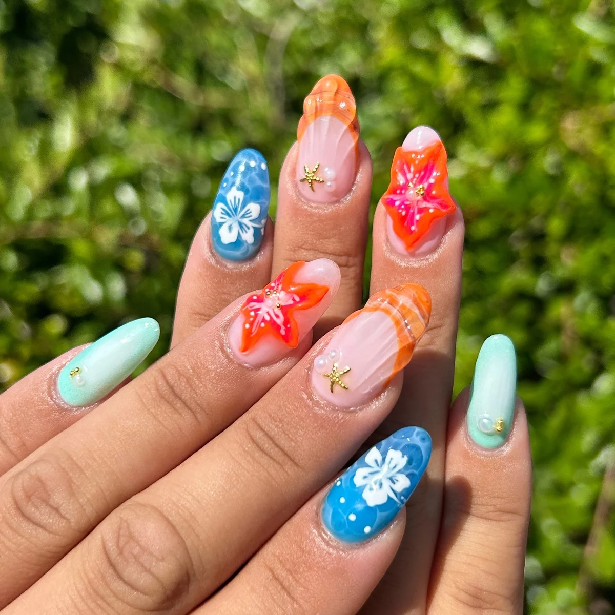 bunte Nägel mit Sternen und Blumen dekoriert - Sommernägel 2025 