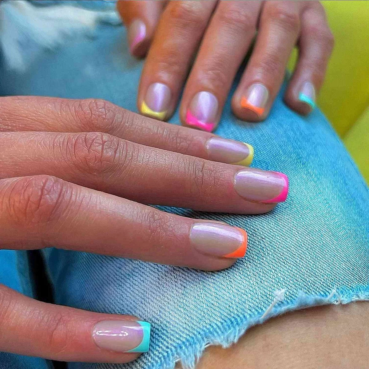 kurze Nägel in blasser Farbe und bunten Spitzen - Sommernägel 2025 