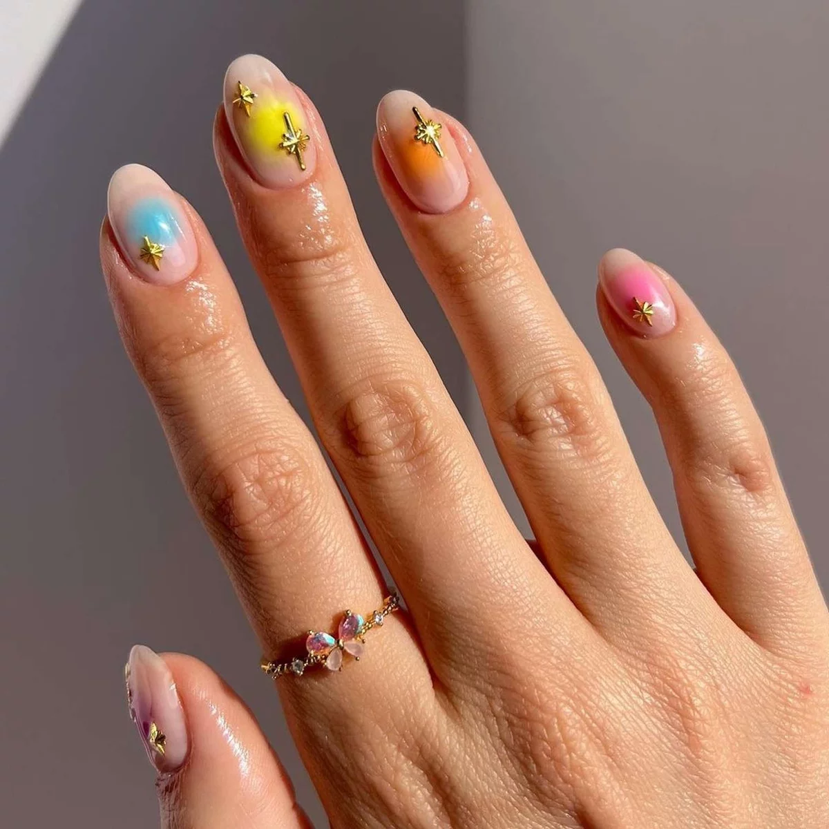 bunte französische Maniküre mit goldglitzernden Sternen 