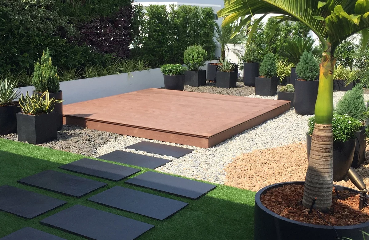 exotische Terrassengestaltung mit vielen grünen Pflanzen und Steintrittplatten 