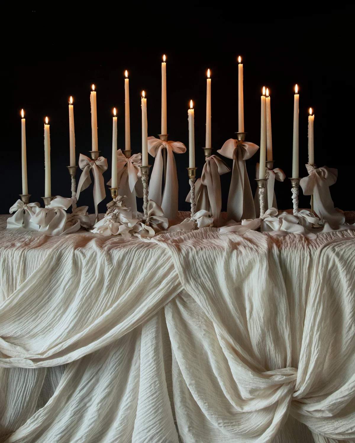 dünne Kerzen mit Schleifen und schöne Tischdecke - Hochzeit Vorbereitungen