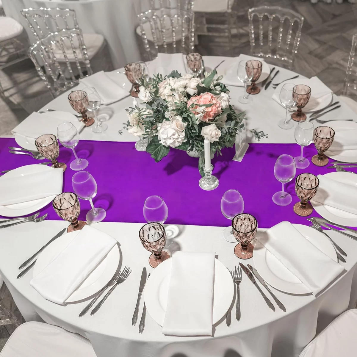 großer runder Tisch mit weißer Tischdecke und lila Tischläufer - perfekte Hochzeit Gedecke