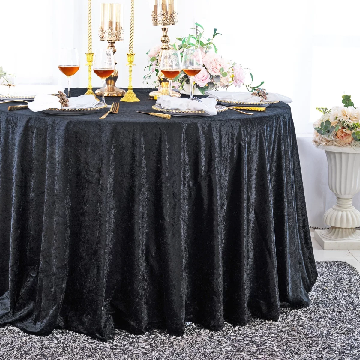 schwarze bodenlange Tischdecke - darauf Geschirr, Weingläser, Kerzen und Blumen