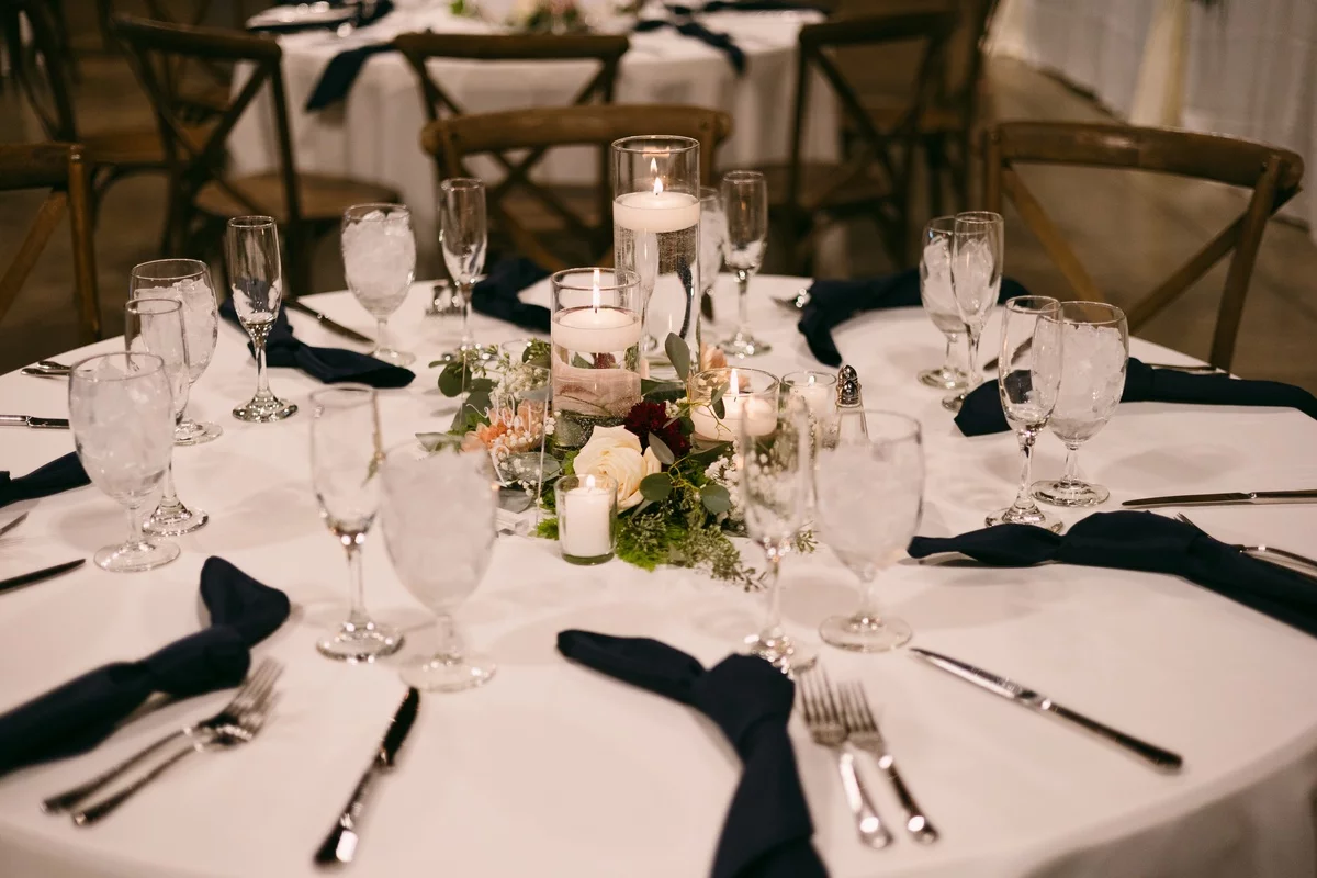 schöne Hochzeit Gedecke Gläser Blumen Kerzen Besateck und schwarze Servietten