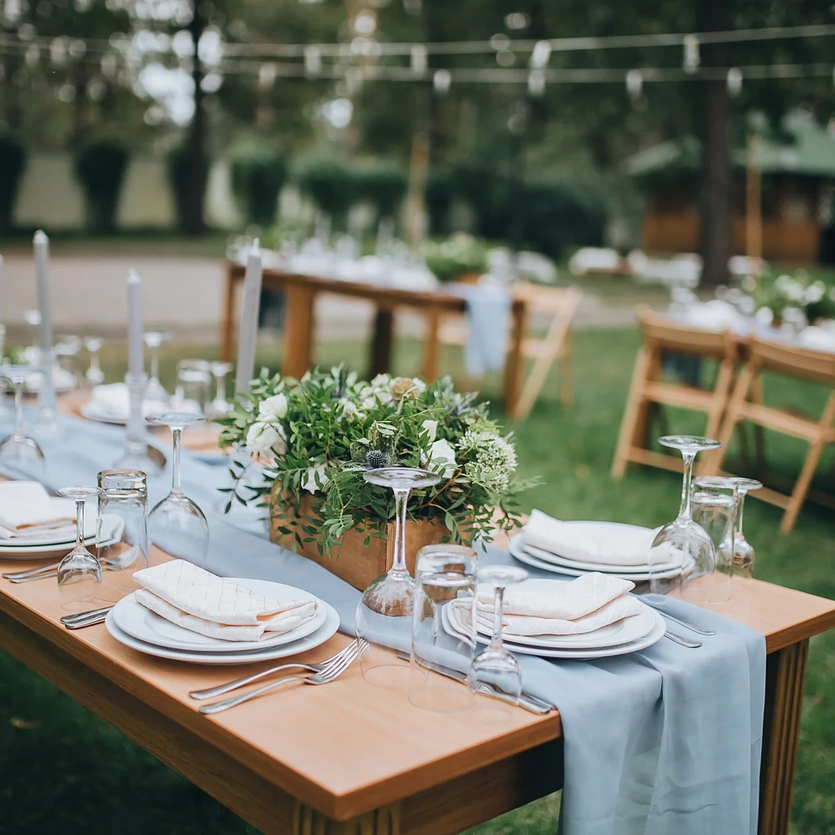 Hochzeit Gedecke für eine Feier im Garten - die Holztische sind gedeckt