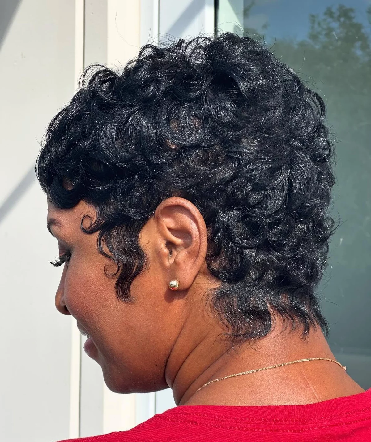 Frau trägt Pixie und hat schwarzes lockiges Haar