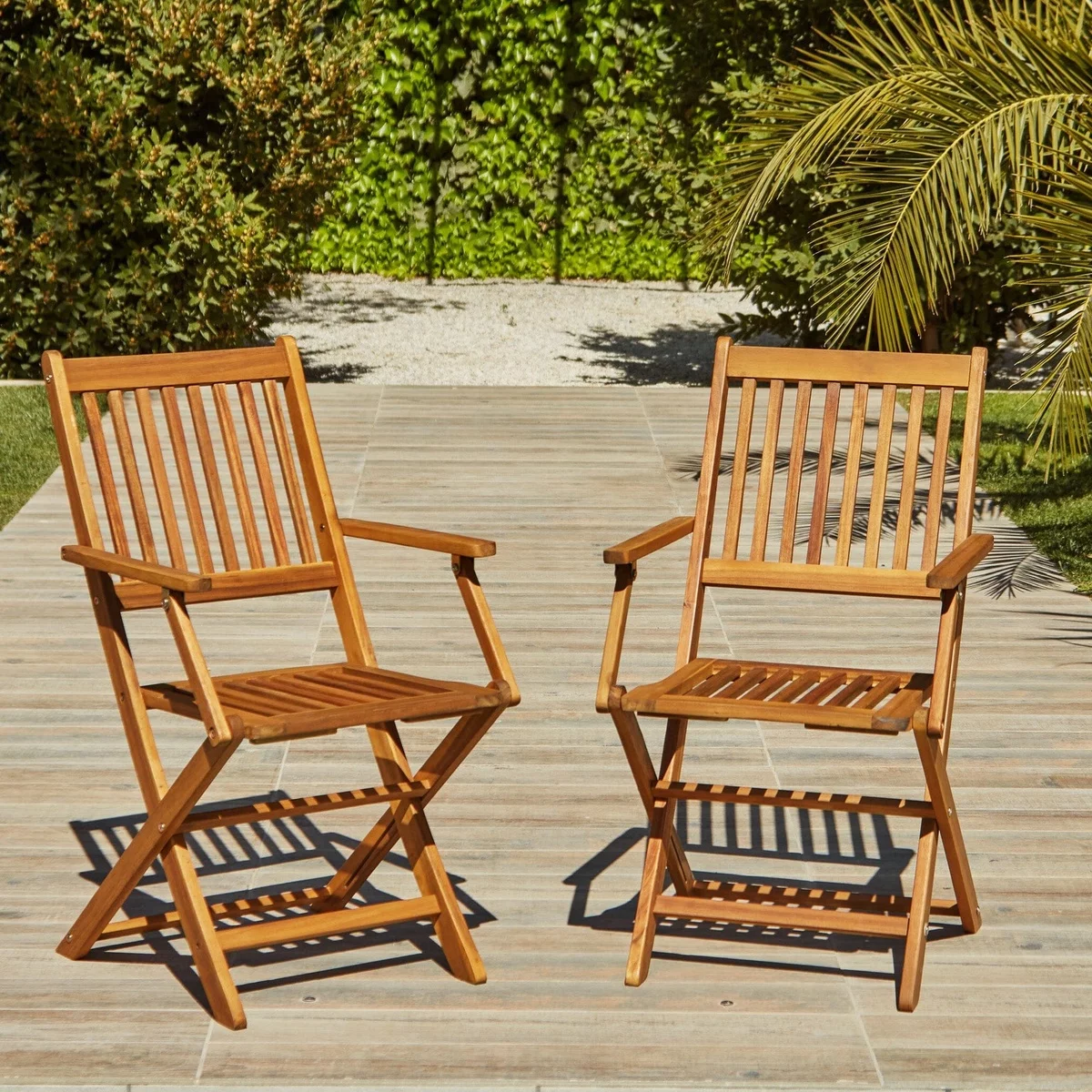 zwei Holzstühle mit Armlehnen im Garten 