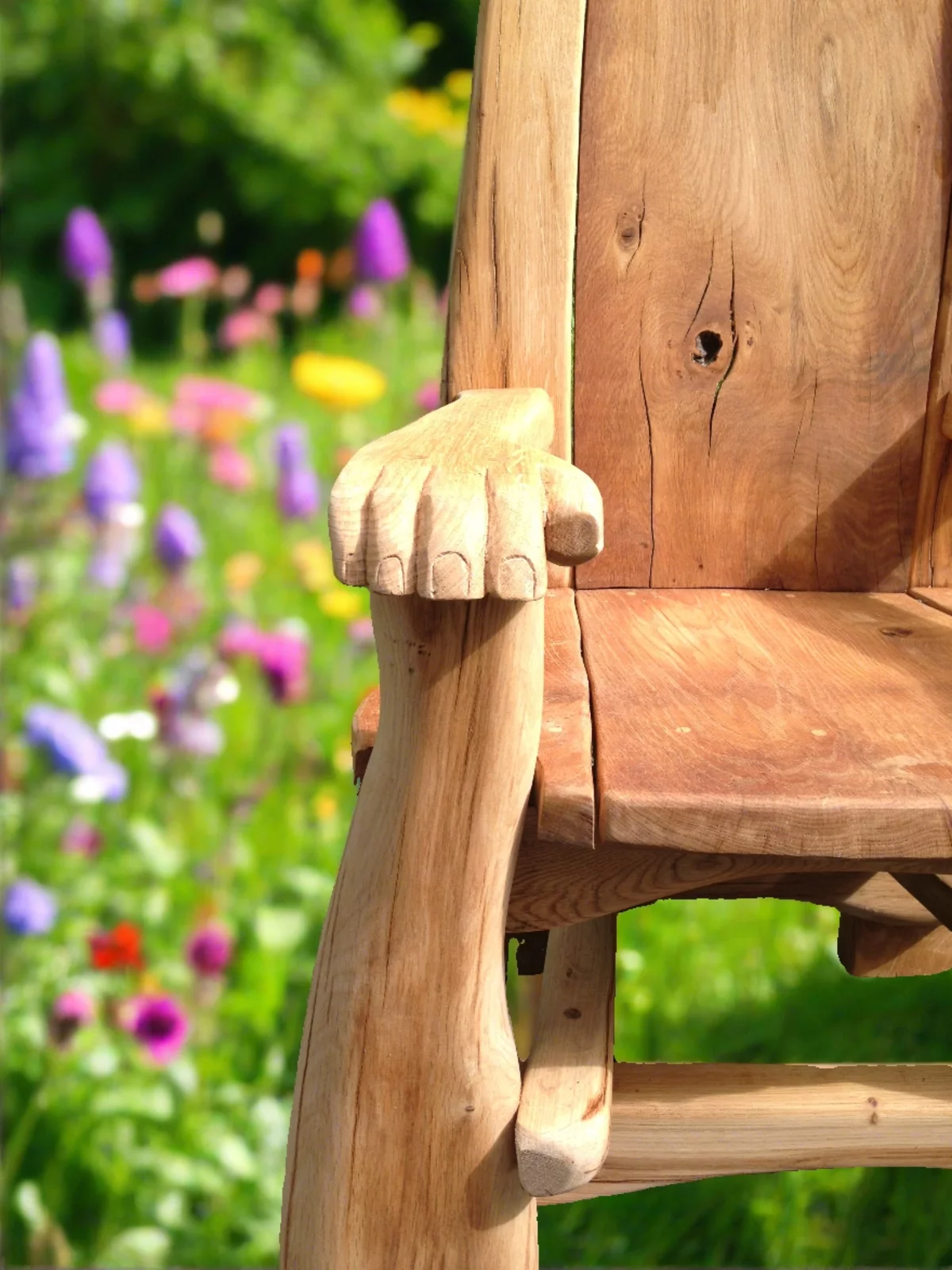 die Armlehne des Holzstuhls ist wie eine Hand geschnitzt 