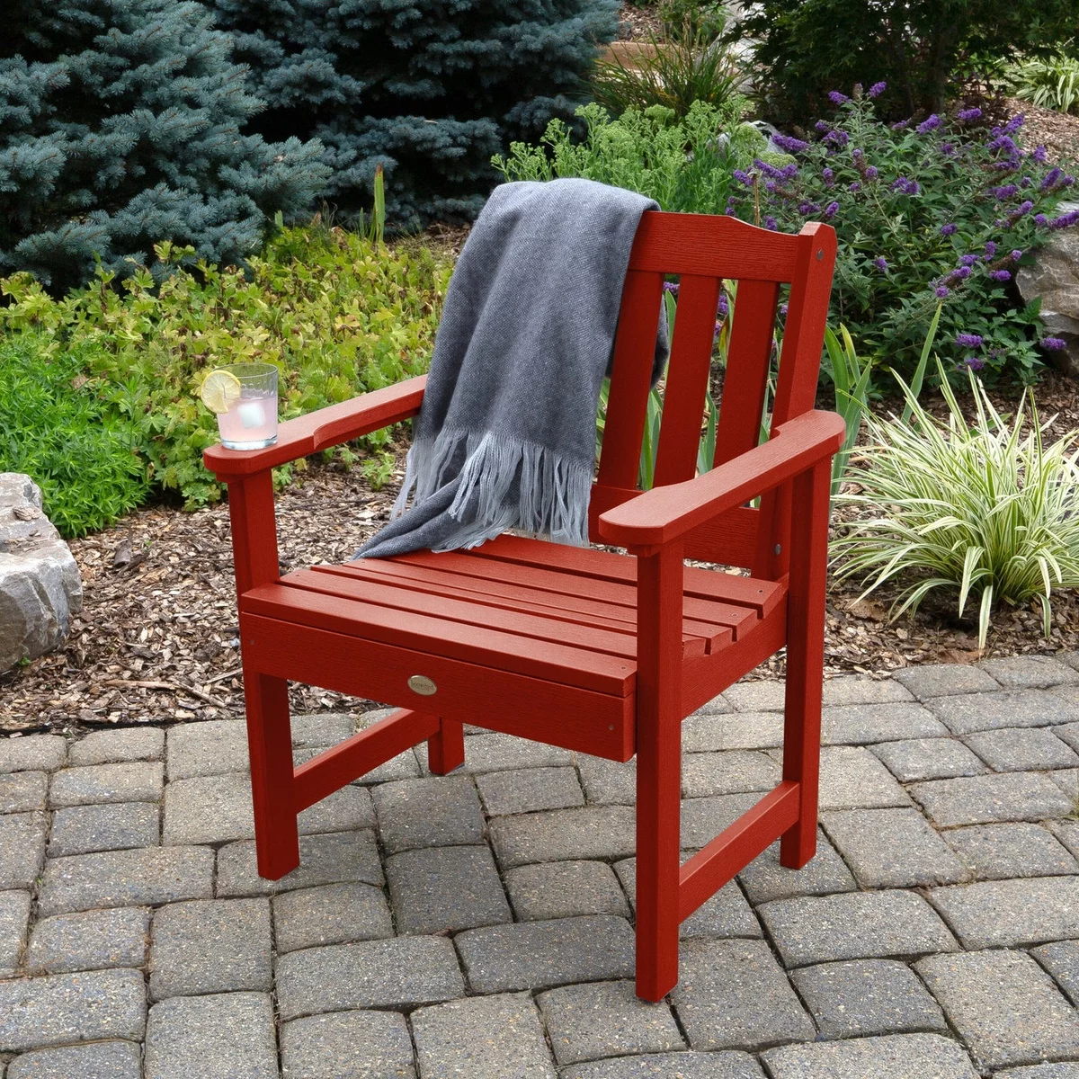 roter Holtstühl mit grauer Wurfdecke im Garten 