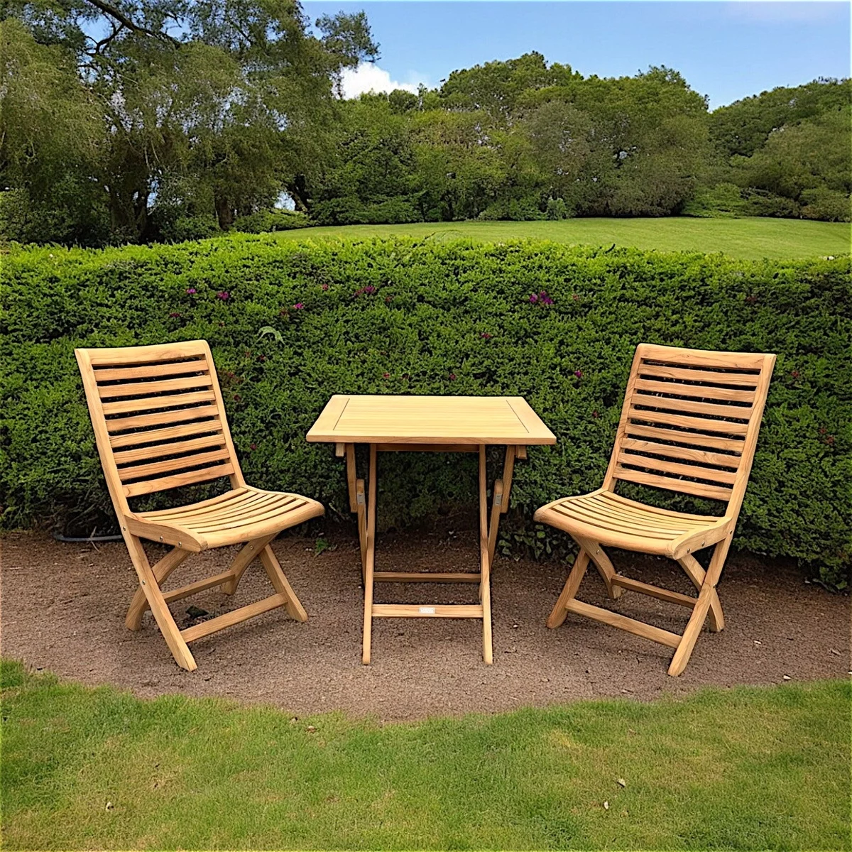 zwei Klappstühle und Klapptisch aus hellem Holz vor dem Zaun platziert