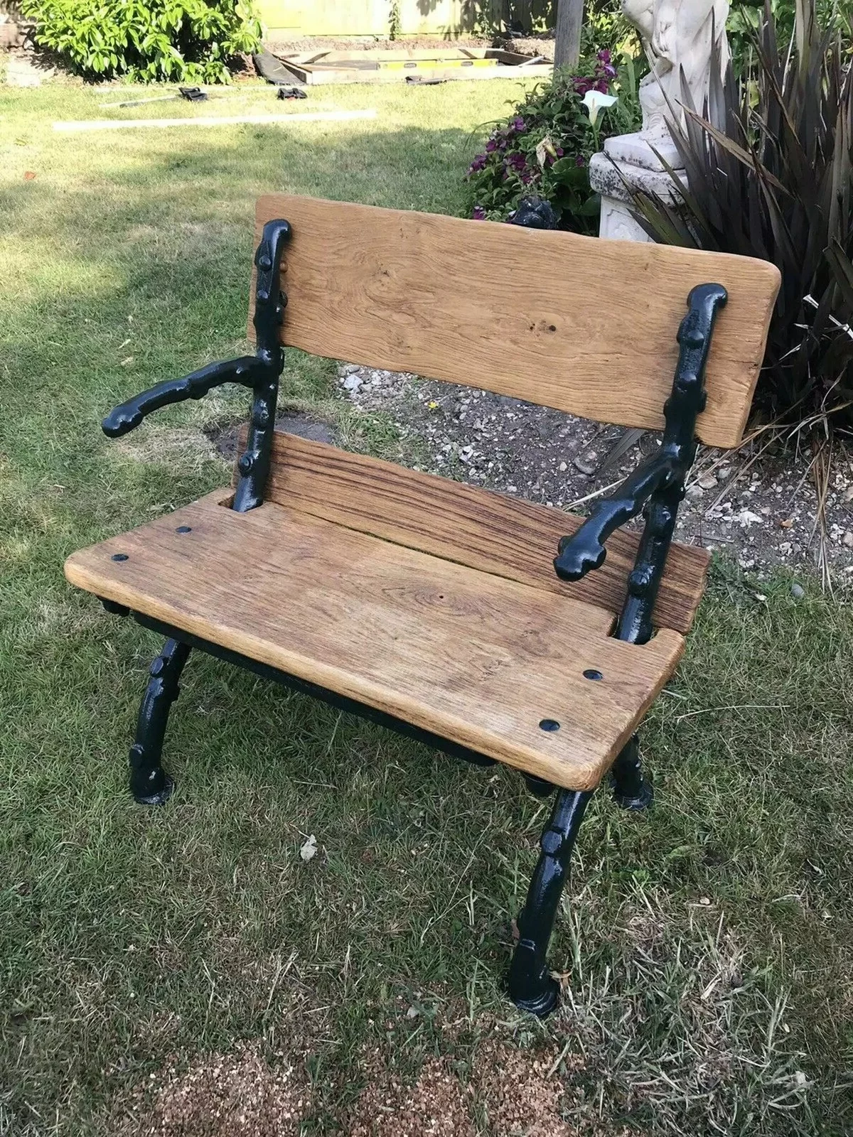 kleine Sitzbank aus Holz und Metall im Garten 