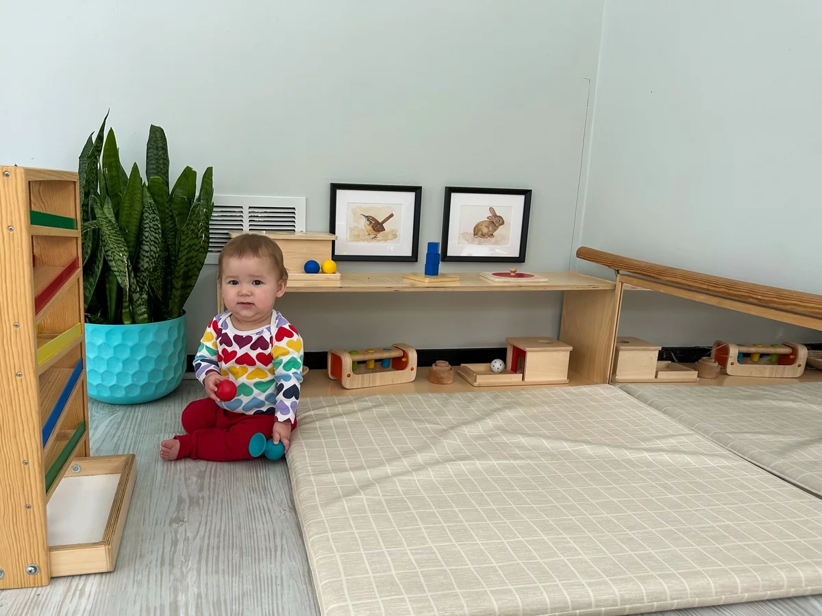 Montessori Spielraum zu Hause - kleiner Junge sitzt auf dem Boden 