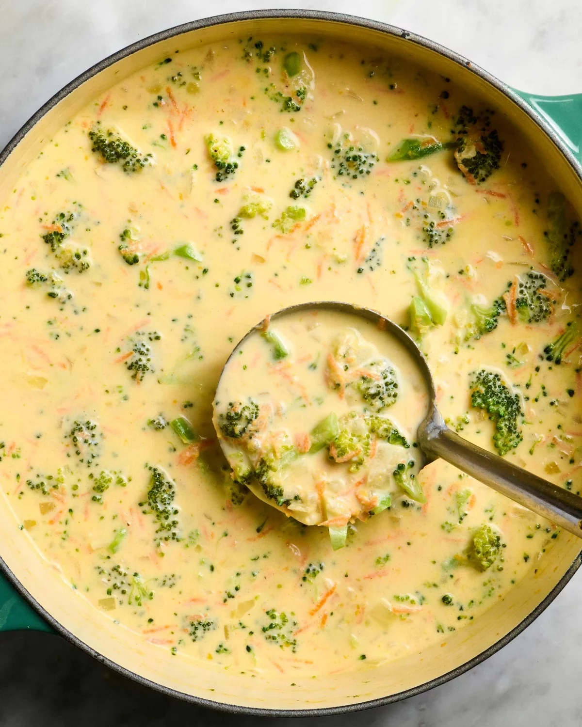 Suppenkelle mit Käsesuppe mit Karotten und Brokkoli 