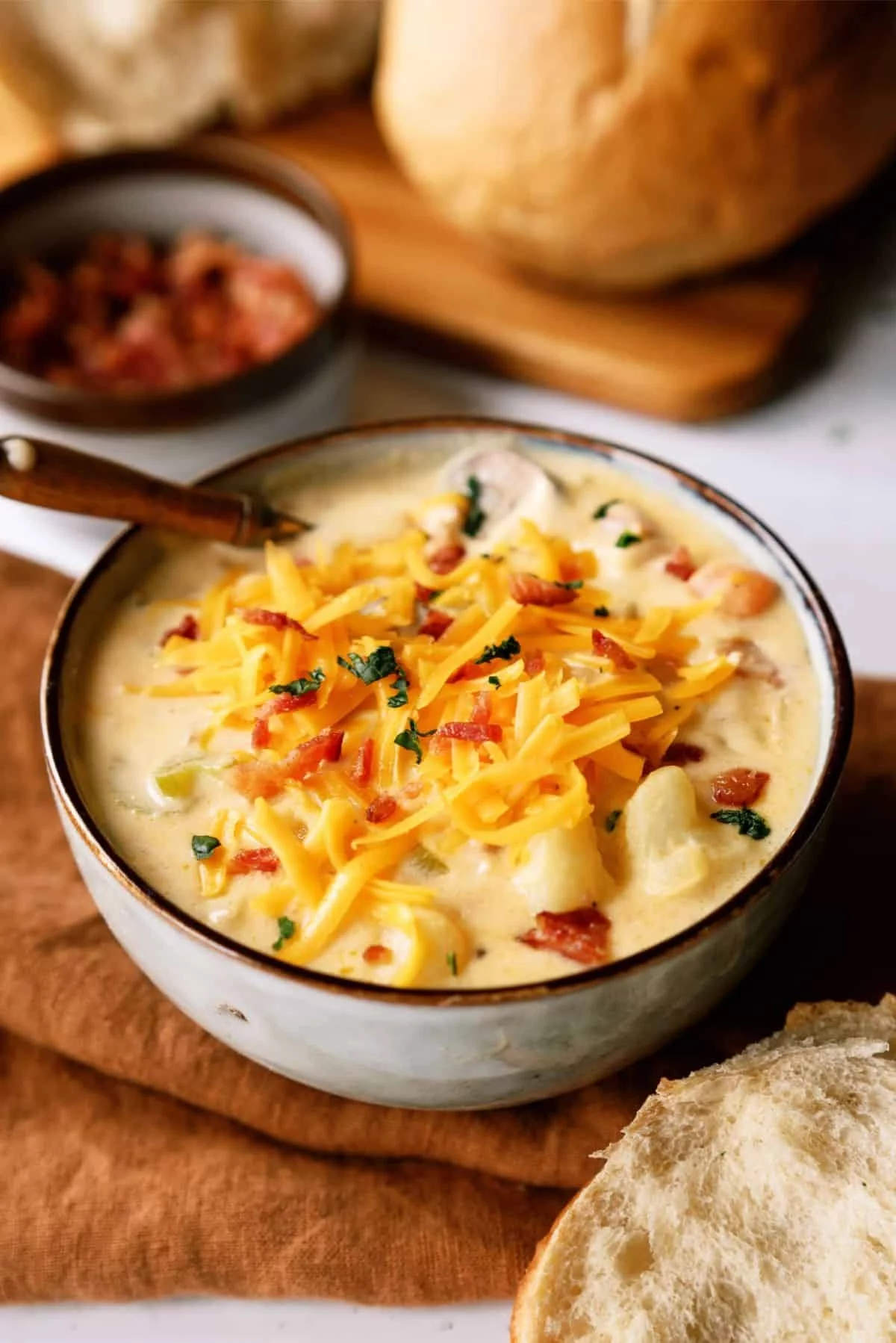 leckere Käsesuppe mit Speck und geriebenem Gelbkäse