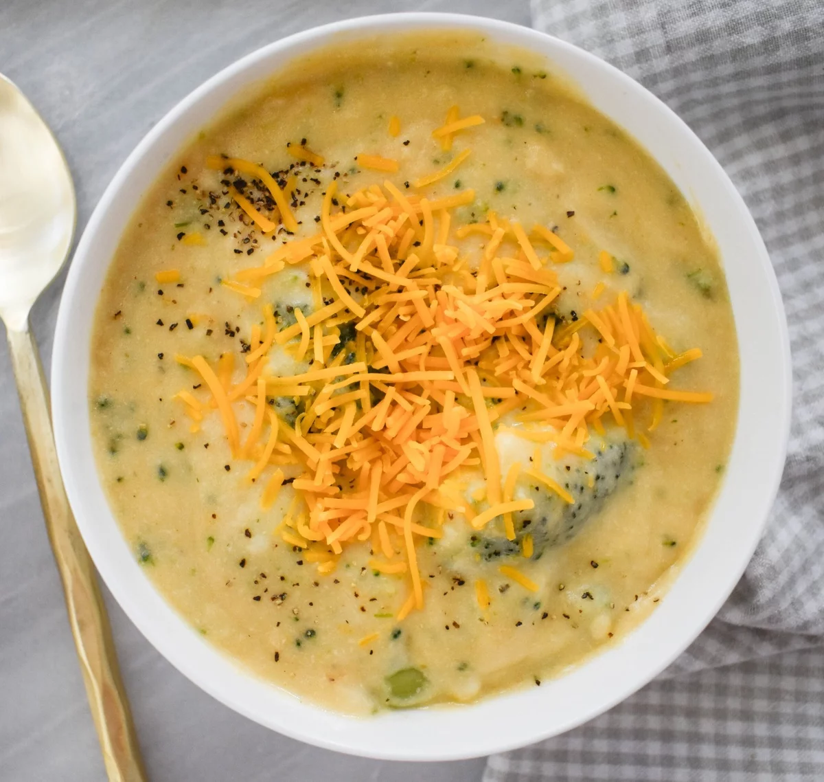 appetitliche Suppe mit Brokkoli und geriebenem Gelbkäse 