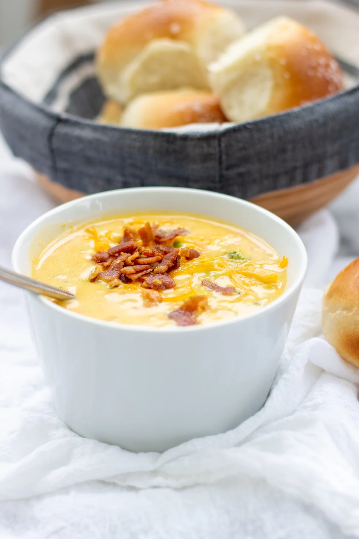 eine Schüssel Käsesuppe und Brötchen daneben