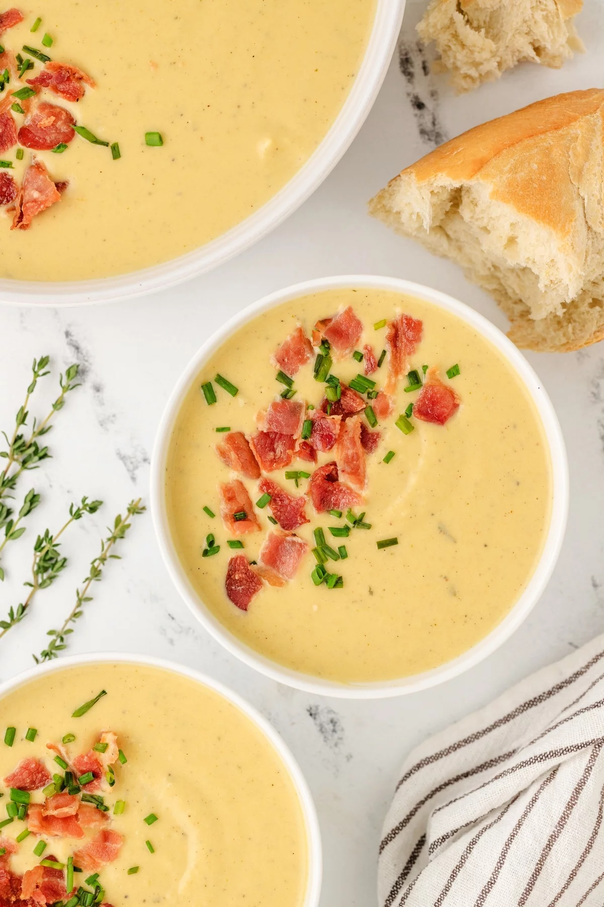 leckere Käsesuppe mit Speck serviert mit frisch gebackenem Brot 