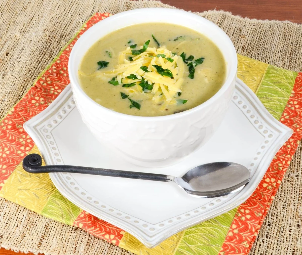 eine Schüssel Käsesuppe mit geriebenem Gelbkäse und Schnittlauch 