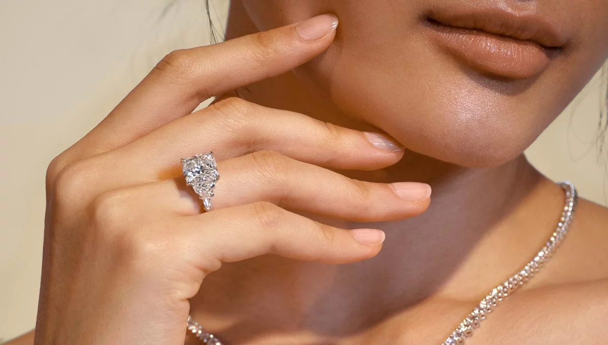 junge Dame mit Verlobungsring mit Edelsteinen und Halskette