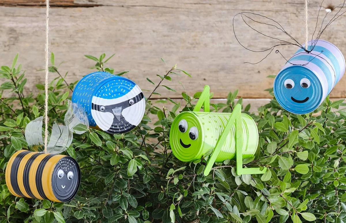 alte Konservendosen in fröhlichen Farben als Bienen und Grashüpfer dargestellt