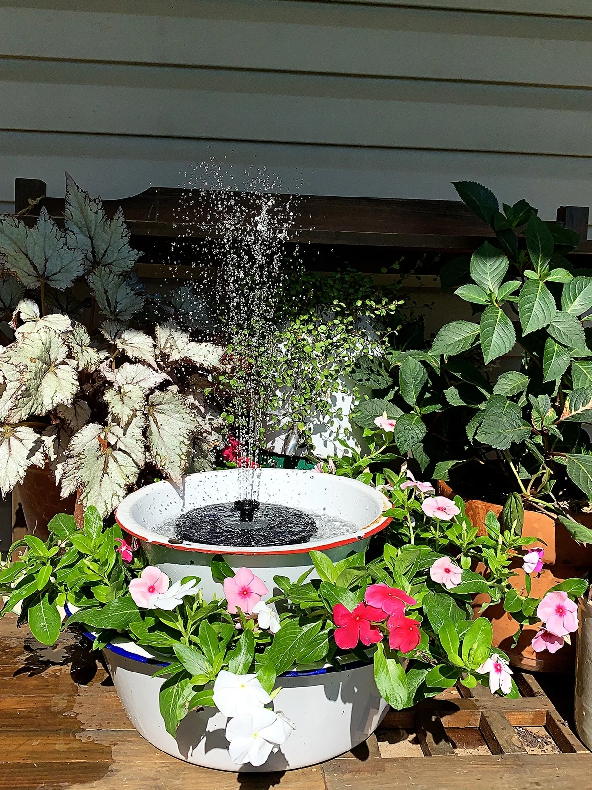 schöne Gartendeko mit farbenfrohe Blumen und Brunnen 