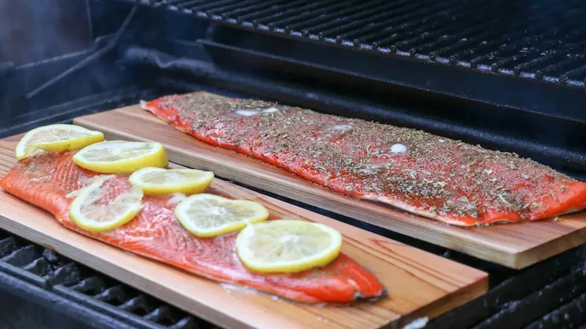 Lachs mit Zitronenscheiben vorbereitet fürs Braten auf dem Rost 