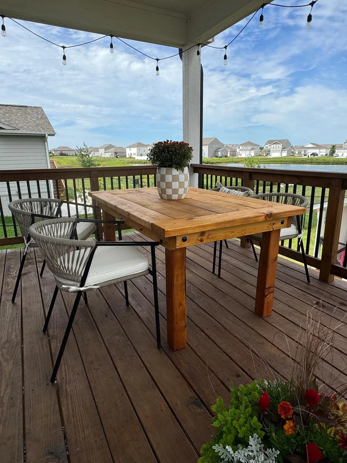 Holztisch auf der Terrasse mit einer Topfpflanze geschmückt 