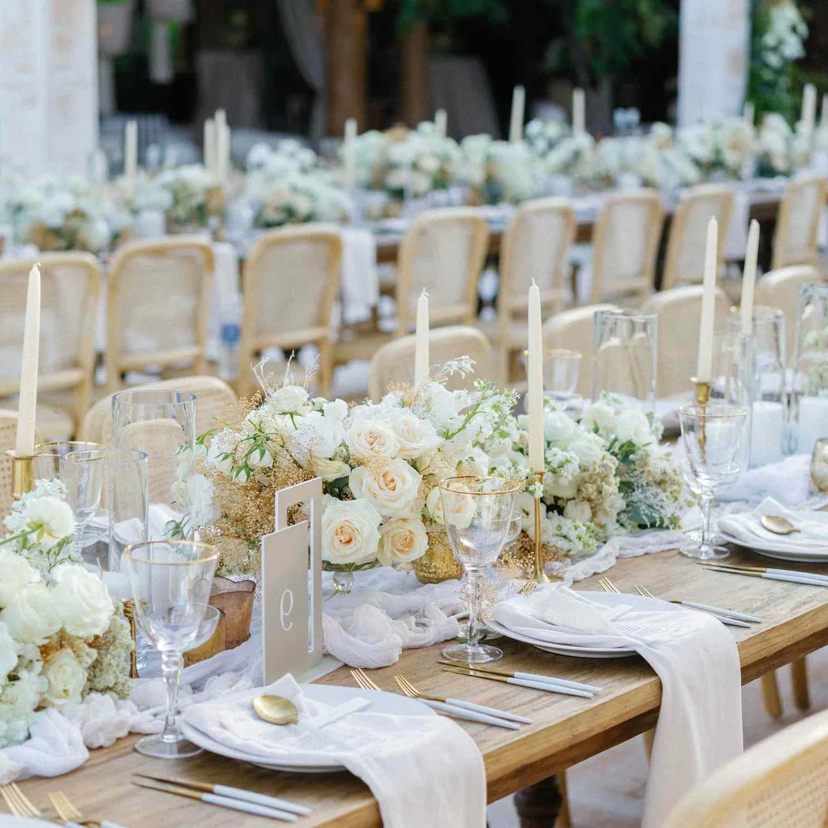 weiße Blumen und Kerzen plus weiße Servietten machen hier eine stilvolle Hochzeit Tischdekoration aus