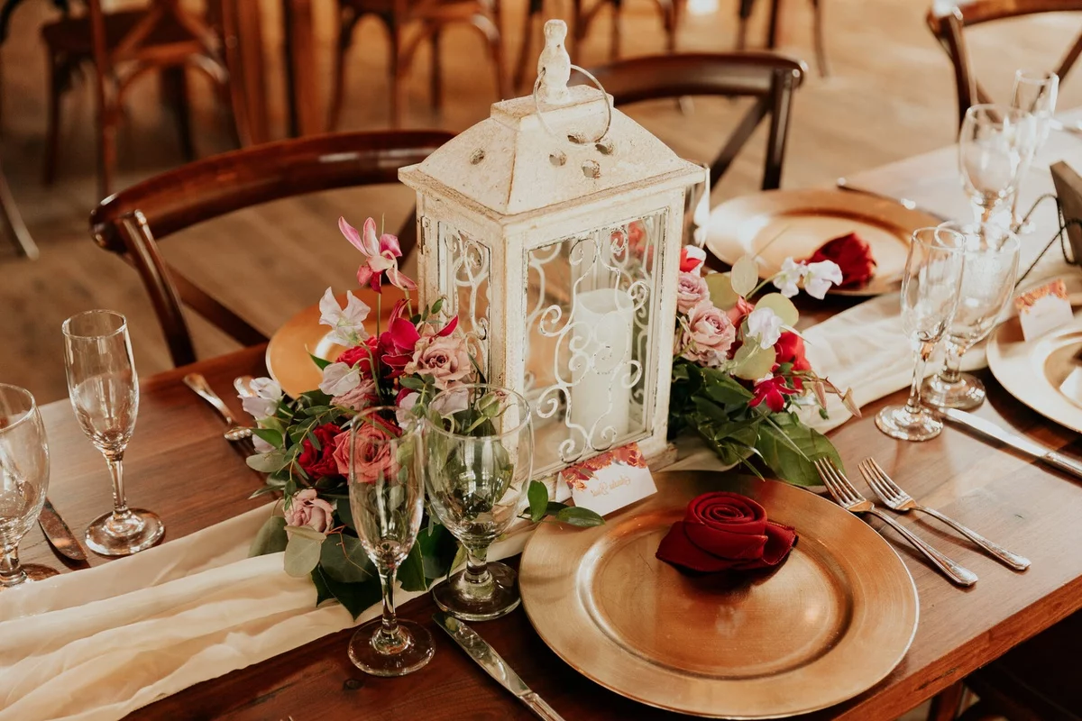 alte Laterne mit Kerzen und Blumen - rustikale Hochzeit Tischdekoration 