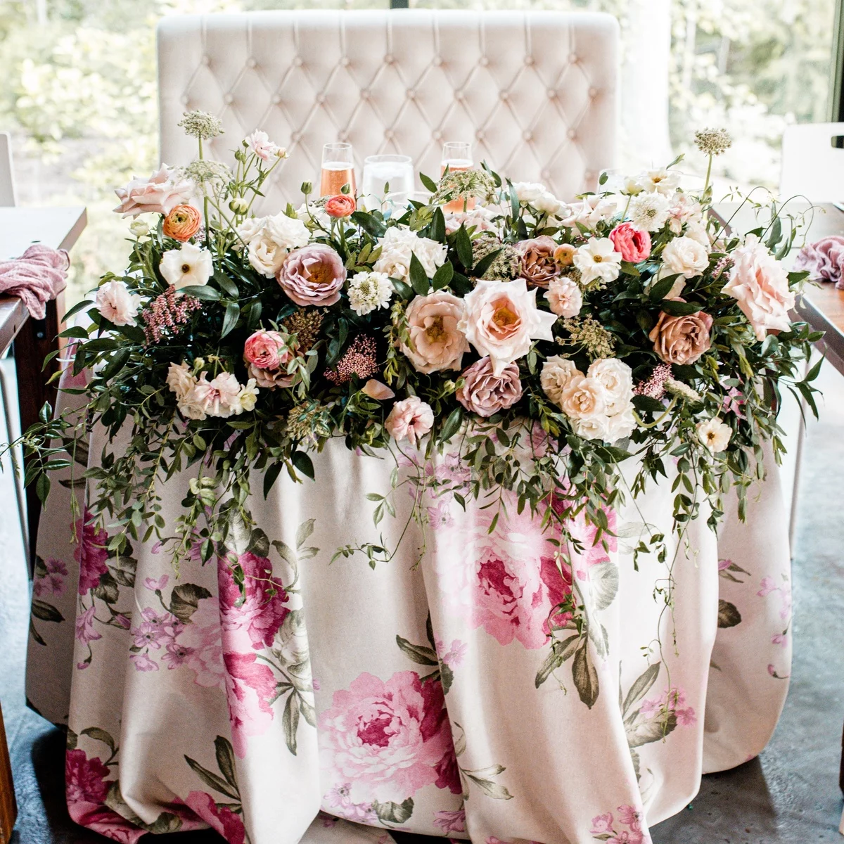 zahlreiche Blüten in zarten Farben schmücken den Hochzeitstisch 