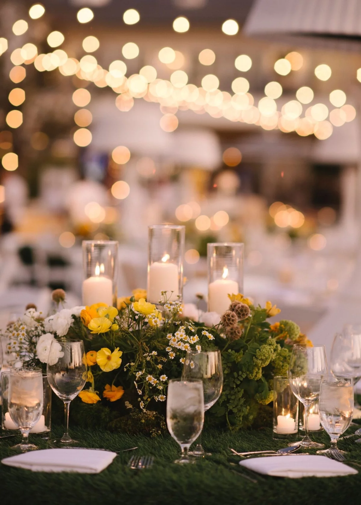 prächtiges Blumenarrangement und glitzernde Lichter - Hochzeit Tischdekoration 