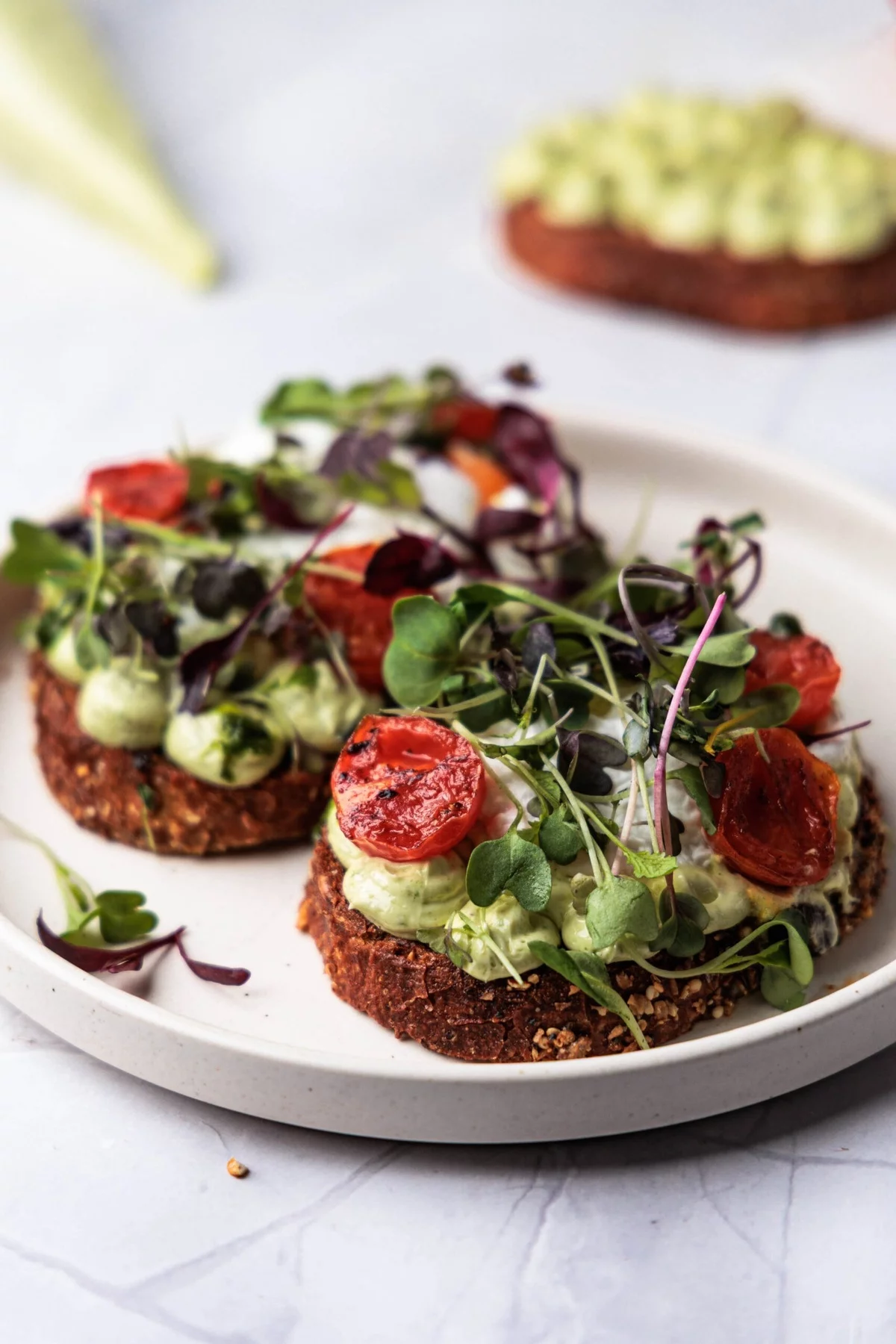 essbare Kräuter auf Schwarzbrot mit Bärlauch Pesto und mit Cherry Tomaten 