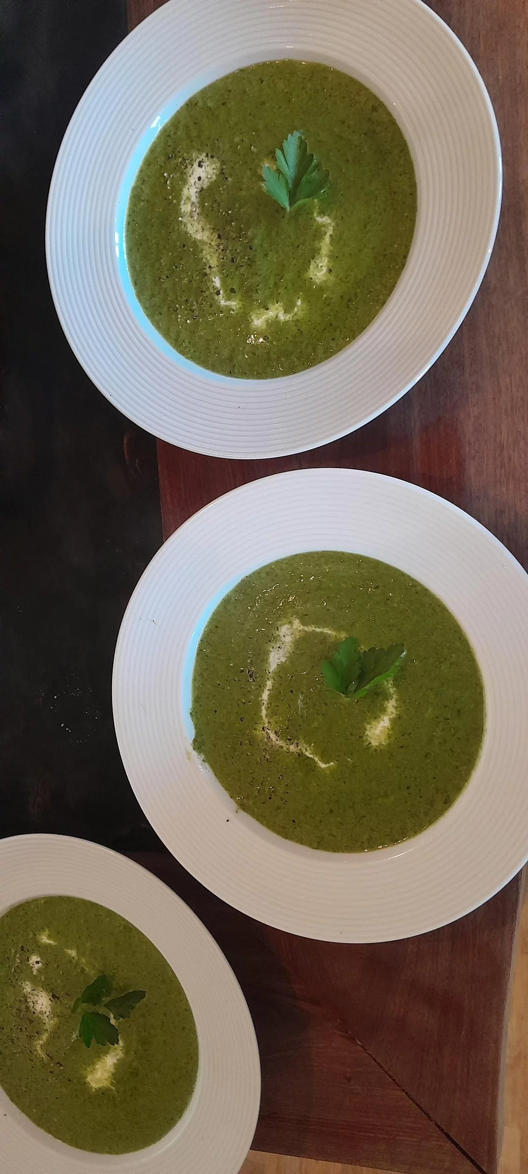 drei Suppenteller Bärlauchsuppe mit Petersilie serviert