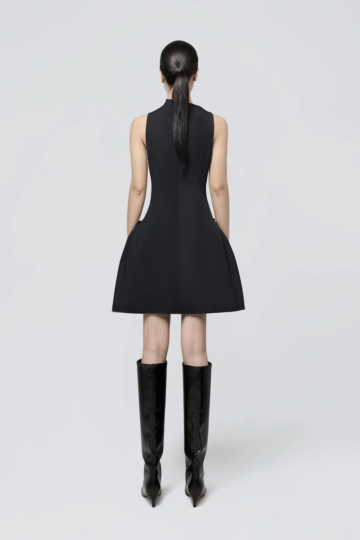 kurzes schwarzes Kleid mit kniehohen schwarzen Stiefeln - lässige Frühlingsmode 