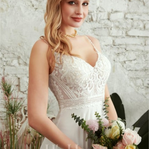 schöne Braut mit sexy Brautkleid trägt einen Blumenstrauß