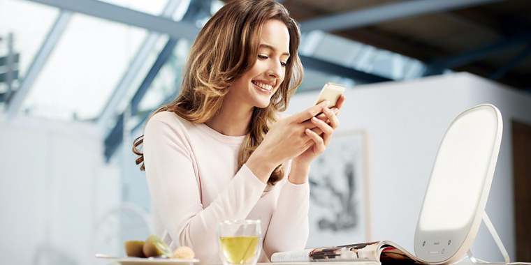 Junge Frau hat eine Tageslichtlampe im Homeoffice