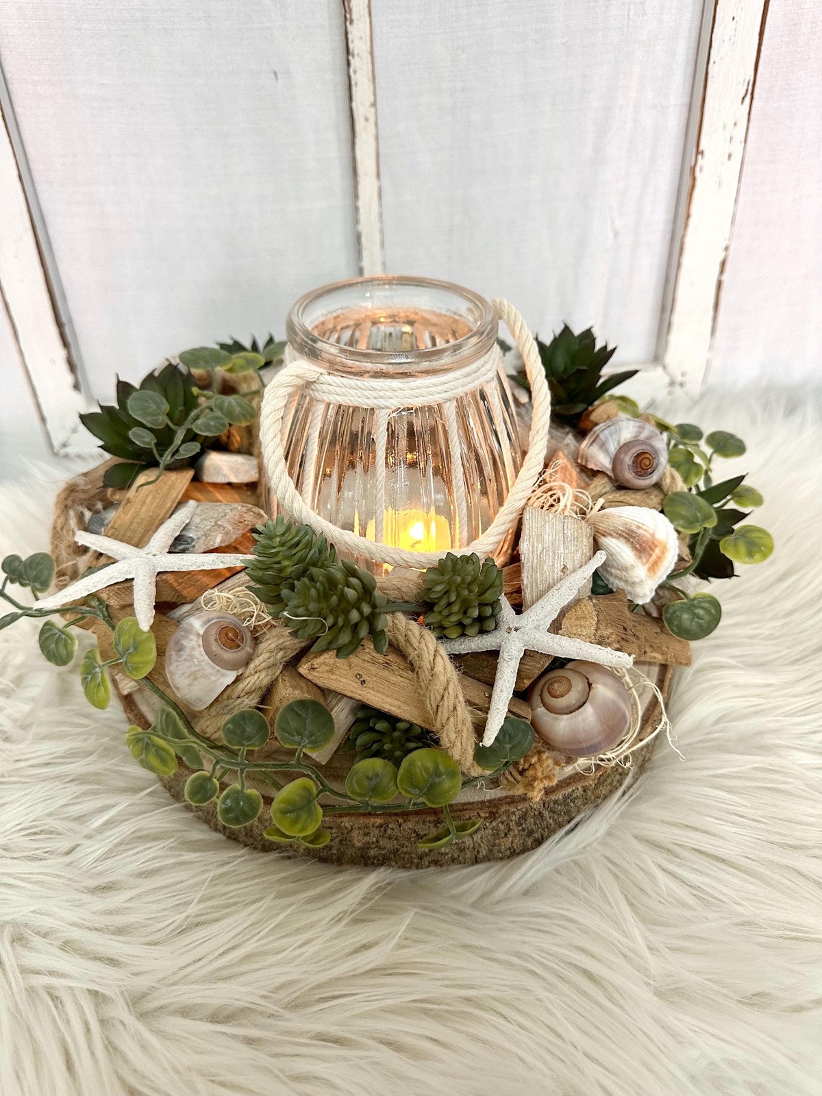 Adventskranz auf Holzscheibe und Laterne mit Muscheln geschmückt 