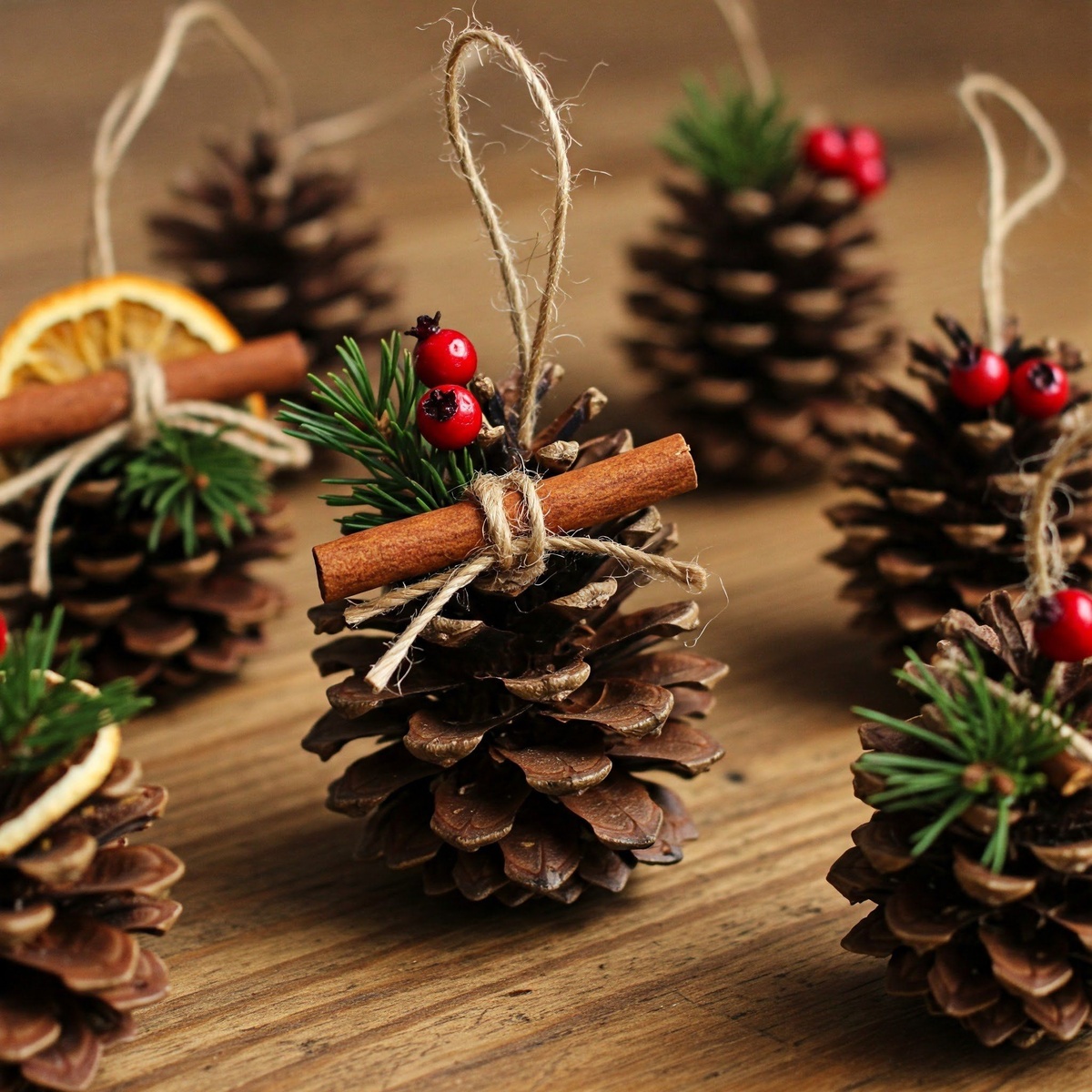 Tannenzapfen als Anhänger mit Zimtstangen dekoriert