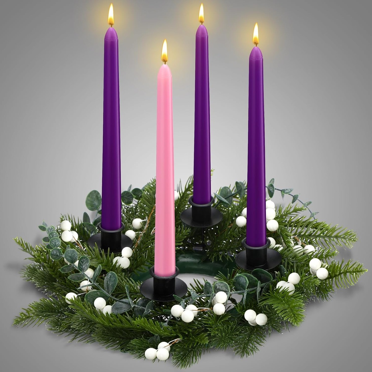 eine rosa und drei lila Kerzen mit Tannengrün und Eukalyptusblättern 